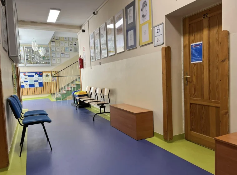 Granatowa wykładzina z żółtym borderem na korytarzu w szkole