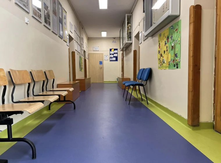 Granatowa wykładzina z żółtym borderem na korytarzu w szkole