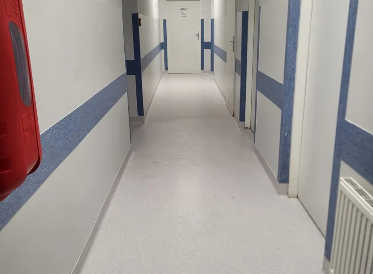 Korytarz w placówce medycznej z szarą wykładziną elastyczną PCW