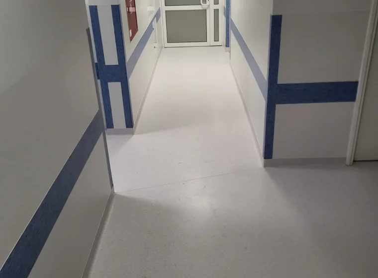 Korytarz w placówce medycznej z szarą wykładziną elastyczną PCW