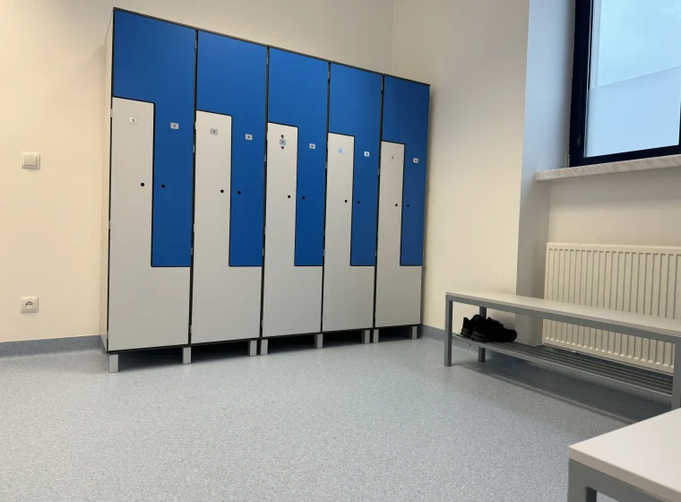 Szatnia w Centralnym Ośrodku Medycyny Sportowej, szafki w szatni szaro niebieskie, podłoga szara Tarkett IQ Granit