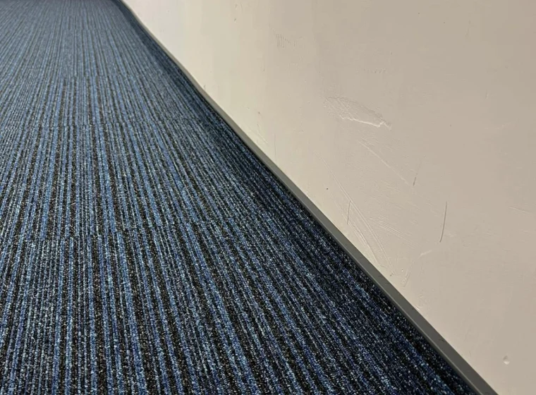 Korytarz i pomieszczenie biurowe w Instytucie Energetyki, granatowa płytka dywanowa o linearnym wzorze