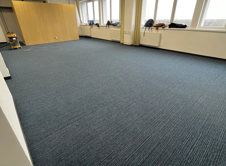 Otwarta sala i przestrzeń w Instytucie Energetyki, granatowa wykładzina o linearnym wzorze w formie płytek dywanowych