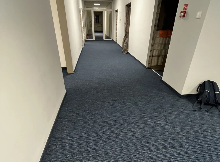 Korytarz w Instytucie Energetyki, granatowa wykładzina w płytkach o linearnym wzorze