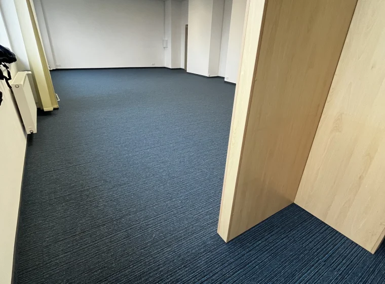 Korytarz i pomieszczenie biurowe w Instytucie Energetyki, granatowa płytka dywanowa o linearnym wzorze